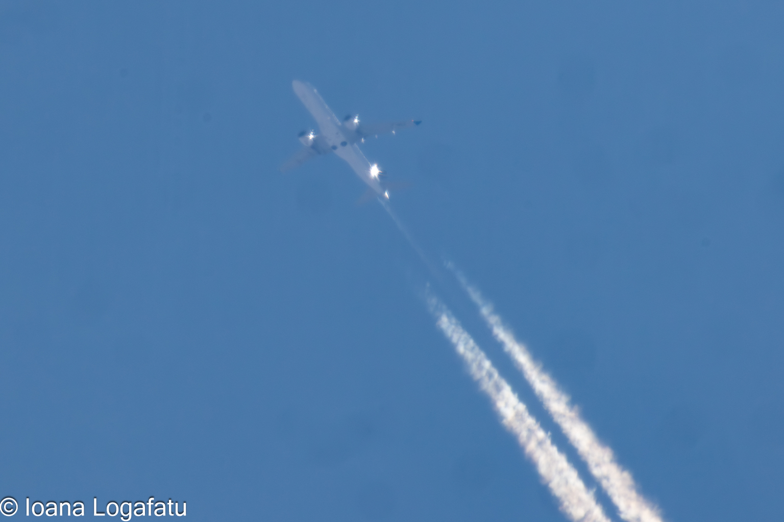 Airplane gliding through a clear blue sky
